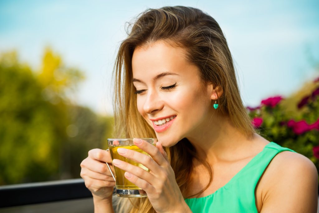 Happy Woman Drinking Green Tea Outdoors