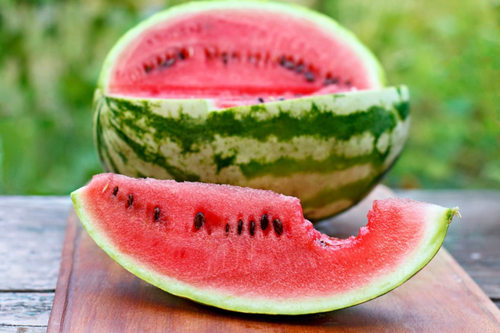 Ripe Watermelon Cut Into Slices On A Wooden Board