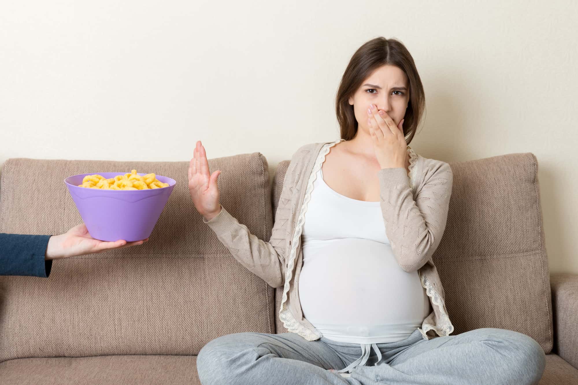 Pregnant Woman Sitting On The Sofa Refuses To Eat Unhealthy Snacks. Stop To The Junk Food During Pregnancy Concept