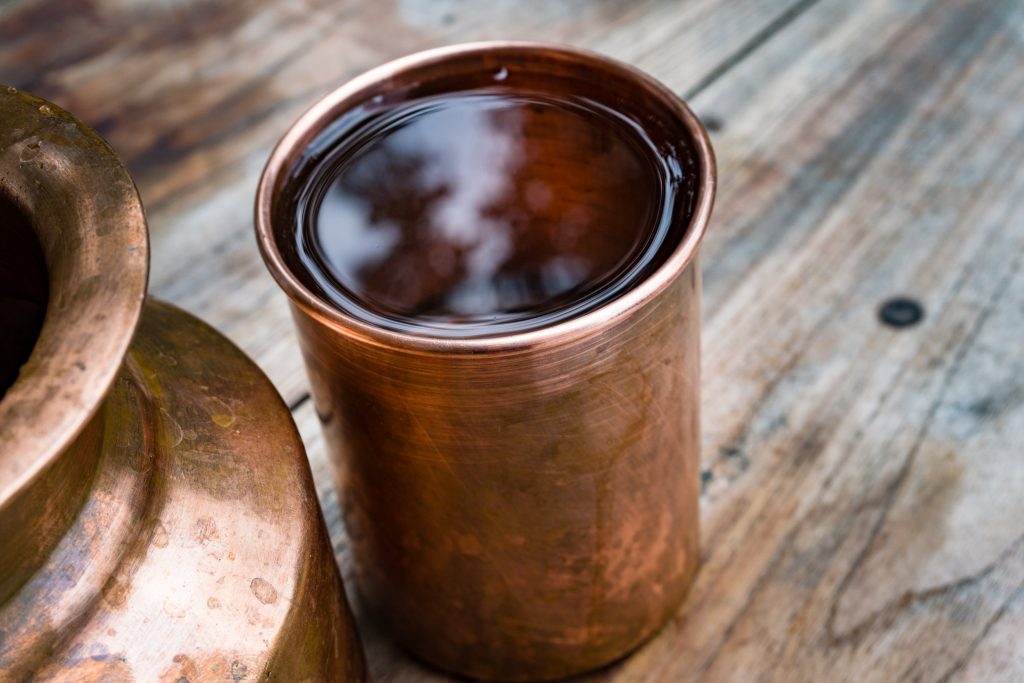 A Copper Water Holder And A Glass. In Indian Ayurvedic Culture It Has Been Established That Drinking Water Out Of A Copper Utensil Has Many Health Benefits.